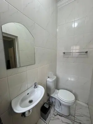 a white bathroom with a toilet and a sink at Michu Guest house in Cape Town