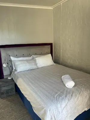 a bed with two pillows on it in a bedroom at Claremont Studio in Cape Town