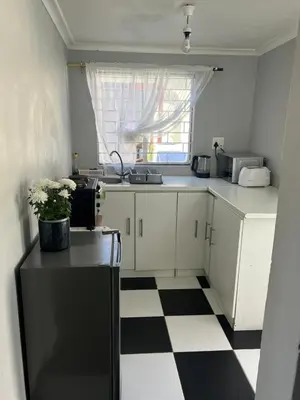 a kitchen with a black and white checkered floor at Claremont Studio in Cape Town