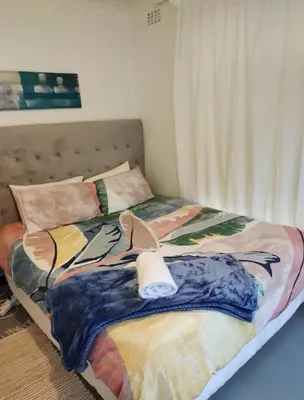 a bedroom with a bed with a blanket on it at Claremont Studio in Cape Town