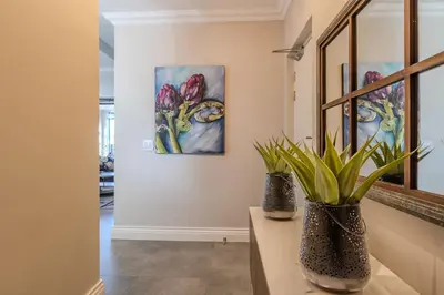 two vases on a table in a room with paintings at Songbird D'Aria Cape Town luxury house on Wine Estate in Cape Town