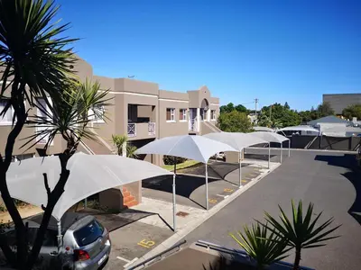 a row of white umbrellas in a parking lot at Smithland Centrally Located Accommodation in Cape Town