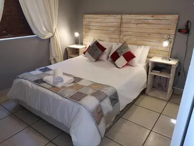 a bedroom with a large white bed with pillows at Smithland Centrally Located Accommodation in Cape Town