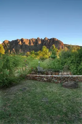 a bench in a field with a mountain in the background at Amberg Country Estate in Paarl