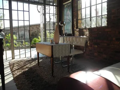 a room with a table and a chair and windows at Amberg Country Estate in Paarl