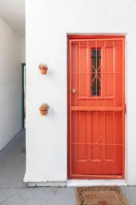 a red door on a white building with plants at Green Haven Apartment in Milnerton in Cape Town