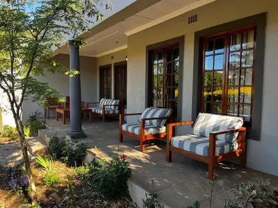 a patio with chairs and tables on a building at Paarl Crystal Family Home in Paarl