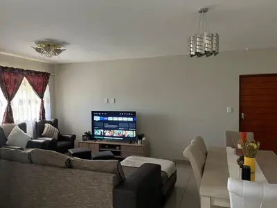 a living room with a couch and a flat screen tv at Alucia in Cape Town