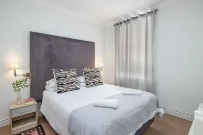 a bedroom with a large white bed with two pillows at Spacious 1 Bedroom Flat Church St Stellenbosch in Stellenbosch