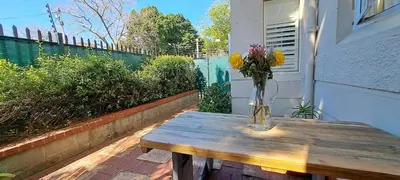 a vase of flowers sitting on a wooden table at Stylish 2-Bed Flat with Exclusive Patio - Easy Access to Cape Town Highlights in Cape Town
