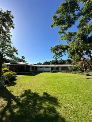 a large building with a large lawn in front of it at Somer House Guest Suites in Somerset West