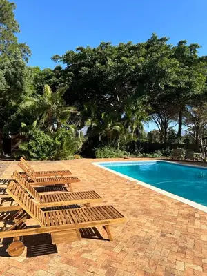 a group of deck chairs next to a swimming pool at Somer House Guest Suites in Somerset West