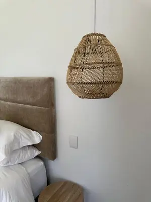 a rattan lamp hanging over a bed in a bedroom at Somer House Guest Suites in Somerset West
