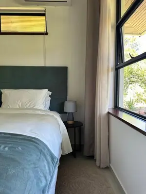 a bedroom with a large bed and a window at Somer House Guest Suites in Somerset West