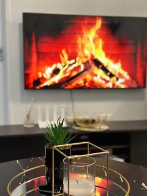 a table with a glass of water in front of a fire at Luxury Stays in Cape Town