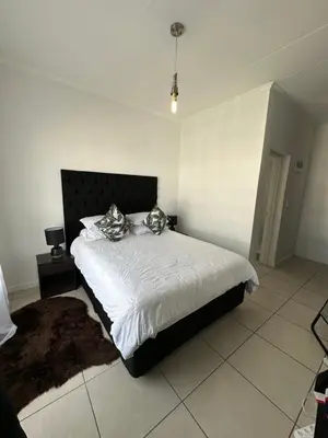 a bedroom with a large bed with a black headboard at Luxury Stays in Cape Town