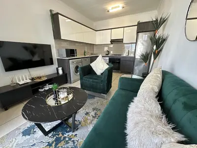 a living room with a green couch and a table at Luxury Stays in Cape Town