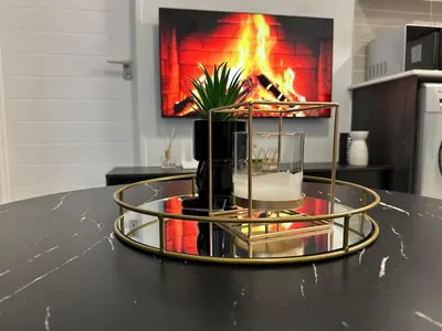 a table with a centerpiece with a fire in the background at Luxury Stays in Cape Town