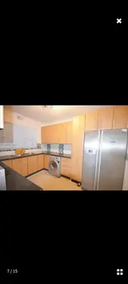 a kitchen with a refrigerator and a washing machine at Sea View Room in Gordonʼs Bay