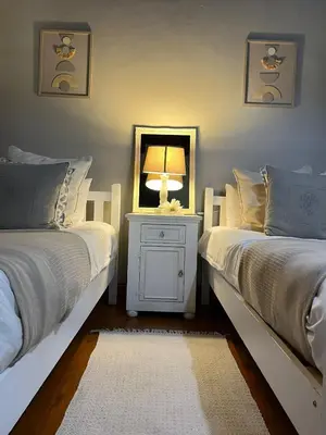 a bedroom with two beds with a lamp and a mirror at Hephzibah inn Guest house and venue in Hermon