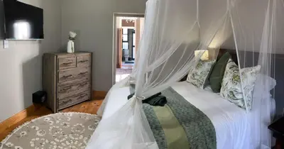 a bedroom with a bed with a canopy at Hephzibah inn Guest house and venue in Hermon