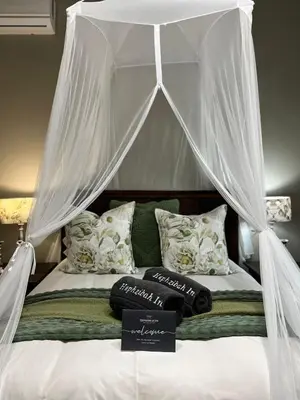 a white canopy bed with pillows and a sign on it at Hephzibah inn Guest house and venue in Hermon