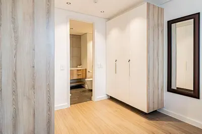 a hallway with a bathroom with a toilet and a mirror at 1 bed flat with Mountain view in Cape Town