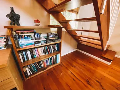 a staircase with a book shelf filled with books at Jonquil Guest Cottage in Franschhoek