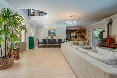 a living room with a couch and a dining room at Luxury Five Bed House in the Heart of Franschhoek in Franschhoek