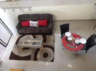 a living room with a brown couch and a table at Coastal Cozy Home in Cape Town
