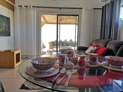 a living room with a glass table with dishes on it at Coastal Cozy Home in Cape Town