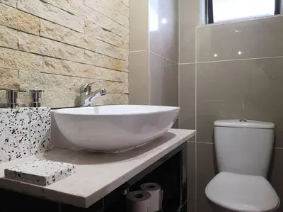 a bathroom with a white sink and a toilet at Coastal Cozy Home in Cape Town