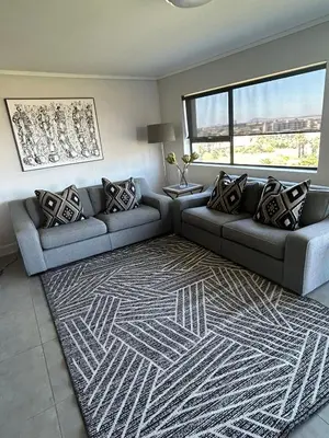 a living room with a couch and a rug at Waters Edge in Cape Town