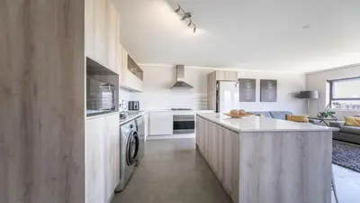 a kitchen with white cabinets and a counter top at Waters Edge in Cape Town