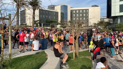 a large crowd of people standing on a sidewalk at Waters Edge in Cape Town