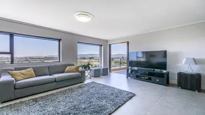 a living room with a couch and a flat screen tv at Waters Edge in Cape Town