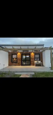 a brick house with a bench in front of it at Brunia Cottage in Bettyʼs Bay