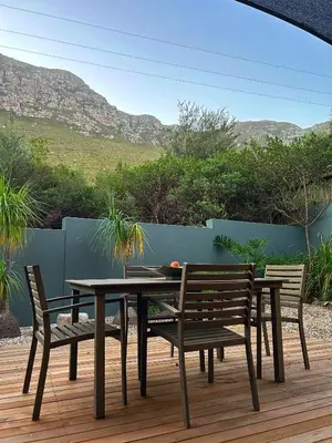a table and chairs on a wooden deck with a view at Villa Silver Vos in Hermanus