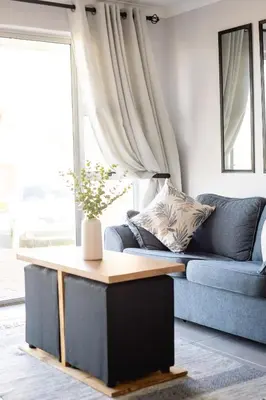 a living room with a blue couch and a table at Ocean Whisper Unit 79 in Hermanus