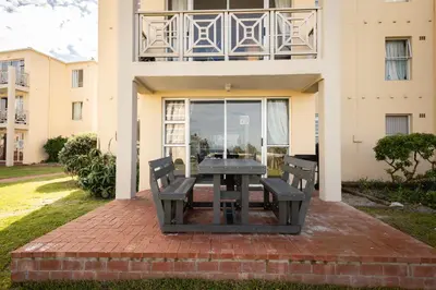 a picnic table in front of a building at Ocean Whisper Unit 79 in Hermanus