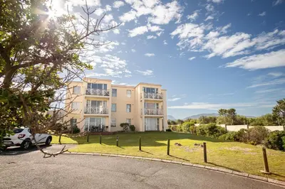 an apartment building with a car parked in the driveway at Ocean Whisper Unit 79 in Hermanus