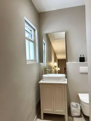 a white bathroom with a sink and a toilet at Stellenbosch Winelands Apartment in Stellenbosch