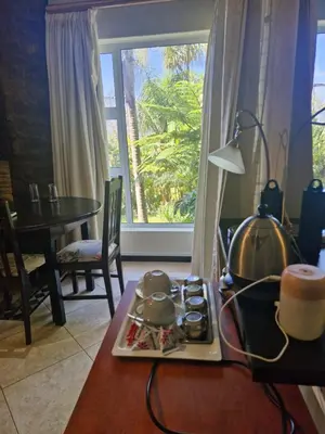 a kitchen with a table with a stove and a window at Lumley's Place Guesthouse in Pniel