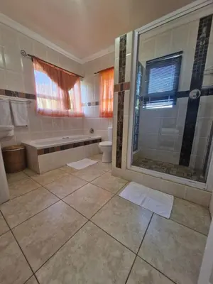 a bathroom with a shower and a toilet at Lumley's Place Guesthouse in Pniel