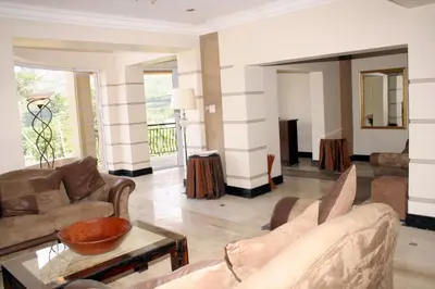 a living room with couches and a table at Lumley's Place Guesthouse in Pniel