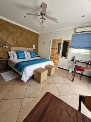 a bedroom with a large bed and a piano at Lumley's Place Guesthouse in Pniel