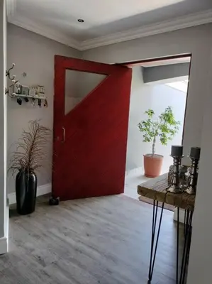 a red door in a room with a table and plants at Champers with a view in Cape Town