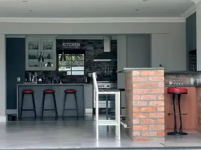 a kitchen with a bar with stools in it at Champers with a view in Cape Town