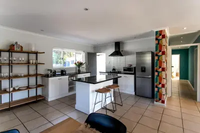 a kitchen with white cabinets and a counter top at Happy Hideaway in Hermanus