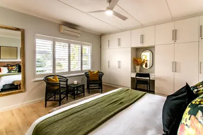a bedroom with a bed and a table and chairs at Happy Hideaway in Hermanus
